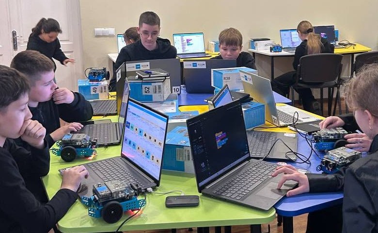 Donated laptops and classroom robot kits on a table at Gimnaziul Dumitru Matcovschi, Soroca. Recipient faces are not published.